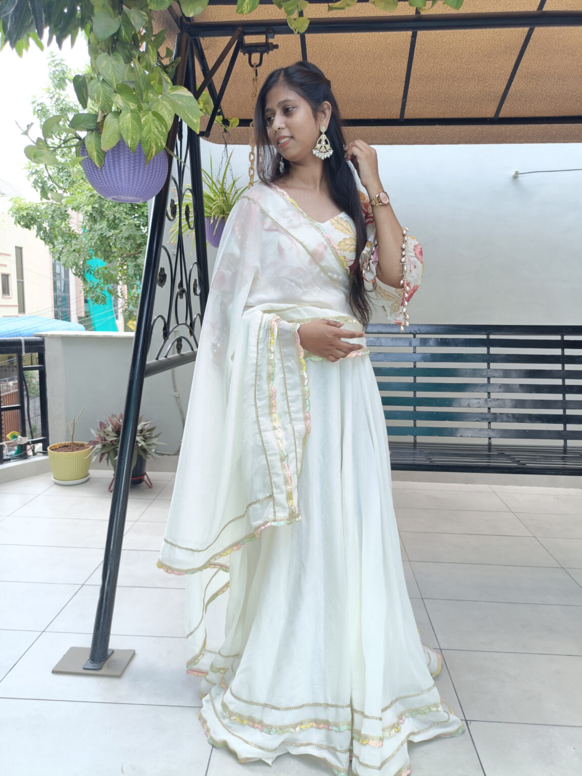 Graceful white lehenga with embroidered borders and floral prints, styled for ethnic fashion